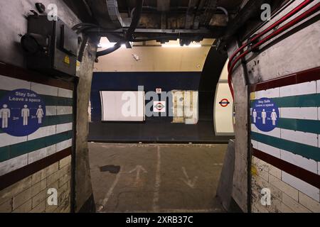 Soziale Distanz-Schilder auf einem stillgelegten Bahnsteig an der U-Bahn-Station Holborn Stockfoto