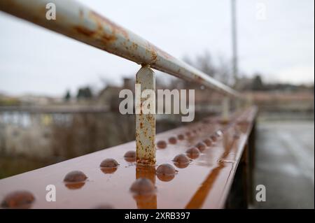 Altes rostiges, nasses Geländer einer kleinen Brücke, regnerischer Tag im Winter Stockfoto