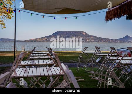 Panoramablick auf die Landschaft durch eine Restaurantterrasse. Küste des Balaton-Sees in Fonyod. Das Balaton-Gebirge ist im Hintergrund. Inklusive Tanu heg Stockfoto