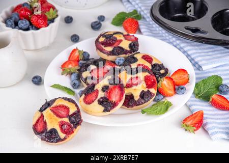 Portionierte gemischte Beerenblätter Pan Baked Pancakes, einfaches Rezept in Muffindosen. Mit frischer Heidelbeere und Erdbeere, Kopierraum Stockfoto