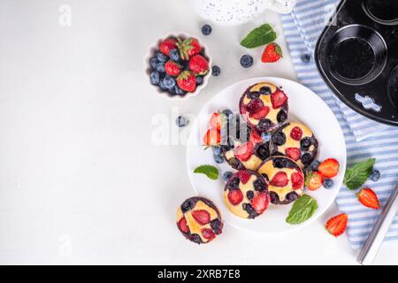 Portionierte gemischte Beerenblätter Pan Baked Pancakes, einfaches Rezept in Muffindosen. Mit frischer Heidelbeere und Erdbeere, Kopierraum Stockfoto