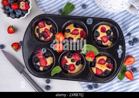 Portionierte gemischte Beerenblätter Pan Baked Pancakes, einfaches Rezept in Muffindosen. Mit frischer Heidelbeere und Erdbeere, Kopierraum Stockfoto