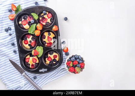 Portionierte gemischte Beerenblätter Pan Baked Pancakes, einfaches Rezept in Muffindosen. Mit frischer Heidelbeere und Erdbeere, Kopierraum Stockfoto