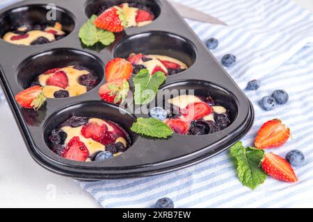 Portionierte gemischte Beerenblätter Pan Baked Pancakes, einfaches Rezept in Muffindosen. Mit frischer Heidelbeere und Erdbeere, Kopierraum Stockfoto