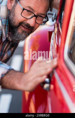 Nahaufnahme eines Mannes, der ein Auto seines neuen Autos hat. Fahrzeug-Liebhaber Konzept mit männlichen Leuten überprüfen glänzend und poliert - Besitzer oder Mechaniker mit Auto . Verz Stockfoto