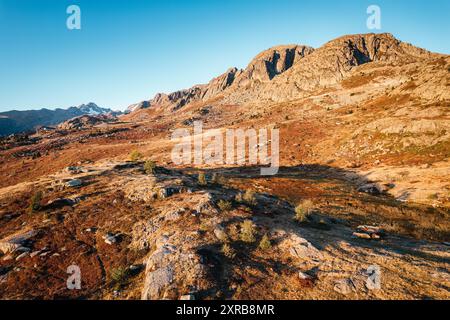 Die französische Alpenlandschaft mit Sonnenaufgang scheint über dem Lac Guichard mit felsigem Berg im Herbst in Savoie, Frankreich Stockfoto