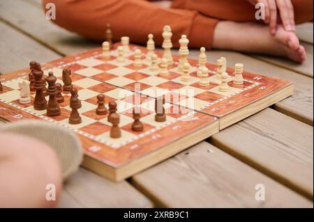 Nahaufnahme eines Schachspiels auf einem Holzbrett. Die Hände der Spieler sind sichtbar und schaffen eine fokussierte und strategische Atmosphäre. Perfekt für Themen von Stockfoto