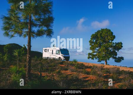 Modernes Wohnmobil Wohnmobil Wohnmobil Parkplatz in der Natur mit Bäumen und Bergen für kostenlosen Park Camping alternativer Garten Haus und Ziel für Urlaub. Sie leben allein von einem Netzreisenden Stockfoto