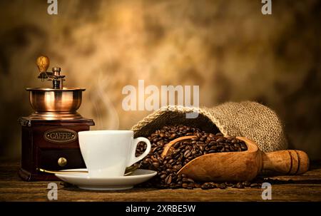 Tasse Espresso-Kaffee, Kaffeebohnen und alte Kaffeemühle auf dem Holztisch. Stockfoto