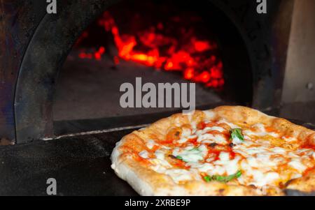 Kochen eine Margherita Pizza aus dem Holzofen. Stockfoto