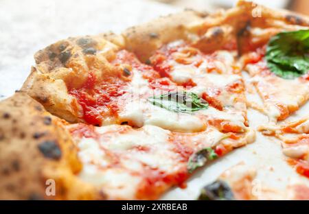 In der Nähe der Scheiben Pizza Margherita mit Basilikum. Stockfoto