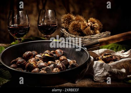 Gebratene Kastanien im Iron Skillet auf hölzernen Tisch. Stockfoto