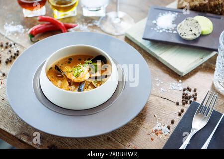 Garnelen-Bisque mit Meeresfrüchten. Riesengarnelen, blaue Muscheln, Kabeljau, Schlagsahne. Köstliches traditionelles Essen in der Nähe serviert zum Mittagessen in modernem Gourmet Stockfoto