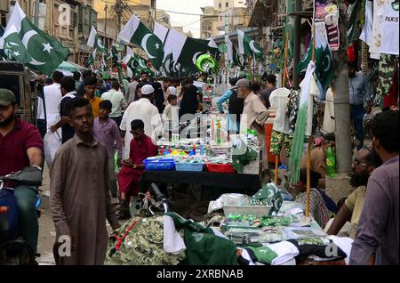 Pakistanische Flaggen, Buntstricke, bedruckte Hemden und andere Artikel werden am Freitag, den 9. August 2024, an Straßenständen am Papiermarkt in Karachi verkauft. Stockfoto