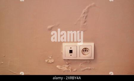 Geschwollene Farbe von Wasser an der Wand. Bemalte Wand, die durch Feuchtigkeit in einer Wohnung beschädigt wurde. Stockfoto