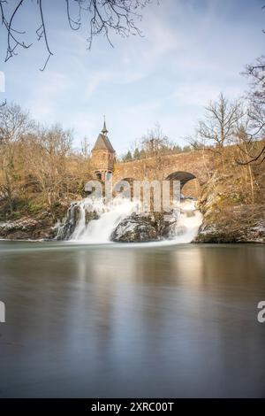 Wunderschöne Landschaft im Winter mit Eis und Schnee. Wasserfall der Eltz bei Schloss Pyrmont, landgasthof Pyrmonter Mühle direkt an einem See, historische Brücke in Rheinland-Pfalz Stockfoto