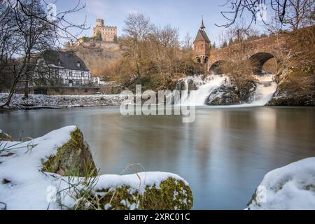 Wunderschöne Landschaft im Winter mit Eis und Schnee. Wasserfall der Eltz bei Schloss Pyrmont, landgasthof Pyrmonter Mühle direkt an einem See, historische Brücke in Rheinland-Pfalz Stockfoto