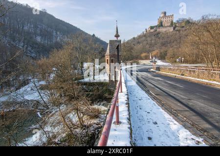 Wunderschöne Landschaft im Winter mit Eis und Schnee. Wasserfall der Eltz bei Schloss Pyrmont, landgasthof Pyrmonter Mühle direkt an einem See, historische Brücke in Rheinland-Pfalz Stockfoto