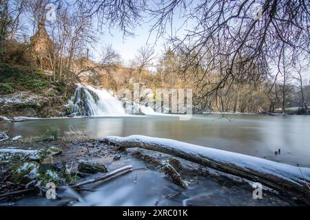 Wunderschöne Landschaft im Winter mit Eis und Schnee. Wasserfall der Eltz bei Schloss Pyrmont, landgasthof Pyrmonter Mühle direkt an einem See, historische Brücke in Rheinland-Pfalz Stockfoto
