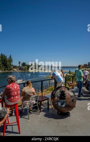 Blick vom Deck des 7 Seas Brewing auf den Eingang zur Bucht von Gig Harbor, einem natürlichen Hafen mit Yachthäfen und Booten in der Stadt Gig Harbor, Stockfoto
