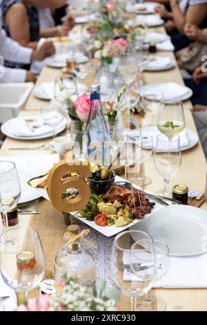 Festlich gedeckter Tisch mit Antipasti- und Blumendekorationen Stockfoto