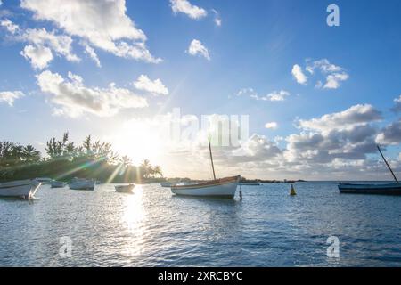 Landschaft mit Blick über einen kleinen Hafen mit Fischerbooten bei Sonnenuntergang am Kap Malheureux, Mauritius Stockfoto