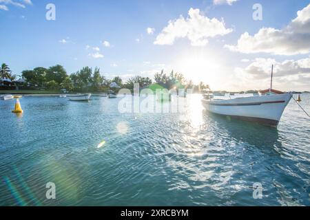 Landschaft mit Blick über einen kleinen Hafen mit Fischerbooten bei Sonnenuntergang am Kap Malheureux, Mauritius Stockfoto