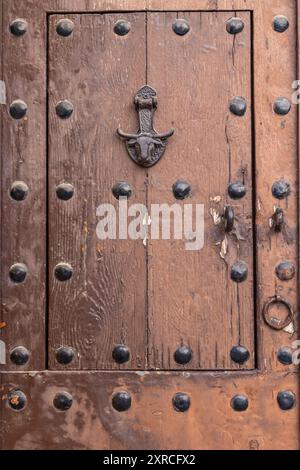 Arcos de la Frontera, Provinz Sevilla, Andalusien, Spanien. Ein antiker Metallklopfer in Form eines Stierkopfes an einer alten Holztür. Stockfoto