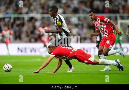 Alexander Isak (Mitte) von Newcastle United und David Lopez von Girona kämpfen um den Ball während des Freundschaftsspiels vor der Saison im St. James' Park in Newcastle upon Tyne. Bilddatum: Freitag, 9. August 2024. Stockfoto