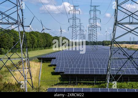 Hochspannungsleitungs Trasse, der Platz darunter wird für einen über 5 km langen Solarpark genutzt, dahinter ein Windpark, im Hafengebiet von Vlissingen-Oost, Niederlande, PV und Windpark *** Hochspannungsleitung, der darunter liegende Raum wird für einen über 5 km langen Solarpark genutzt, dahinter ein Windpark, dahinter ein Windpark, im Hafengebiet von Vlissingen Oost, Niederlande, PV und Windpark Stockfoto