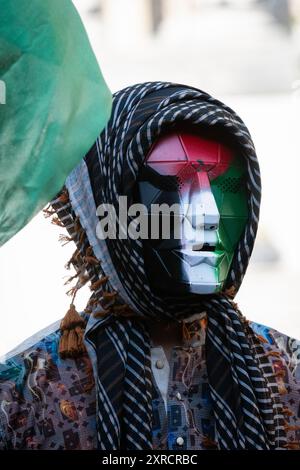 London, Großbritannien. August 2024. Ein Aktivist trägt eine Maske mit den Farben der palästinensischen Flagge, während palästinensische Unterstützer sich in Solidarität mit einem Studentenlager zusammenschließen, das auf dem Gelände des University College London (UCL) für hundert Tage eingerichtet wurde, um gegen den Krieg in Gaza zu protestieren und das College von Israel zu trennen. Die UCL "Camp 4 Justice" hat die Entscheidung getroffen, nach rechtlichen Drohungen durch die College-Behörden zu gehen, die, wie sie sagen, "ruinös teuer" zu verteidigen wären. Quelle: Ron Fassbender/Alamy Live News Stockfoto