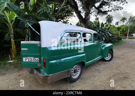 600 Weißdach grünes amerikanisches klassisches Nutzfahrzeug (Ford von 1947), das bei Sonnenuntergang am Playa Manglito Beach auf Passagiere wartet. Baracoa-Kuba. Stockfoto