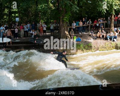 München, Deutschland - 8. Juli 2024: Flusssurfen. Attraktion für Sportfans und Touristen in der Stadt, selektiver Fokus Stockfoto