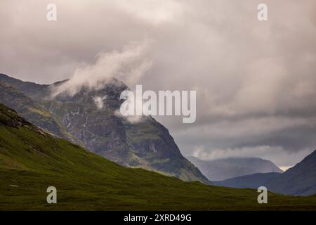 Glencoe, Schottland, Großbritannien. Juli 2024. Blick hinunter nach Glencoe, vorbei an den Bergen und den Sturmwolken. Glencoe in den westlichen schottischen Highlands. Die Gegend ist bekannt für Wasserfälle und Wanderwege, die Gipfel wie Buachaille Etive Mor und Bidean nam Bian erklimmen. Glencoe, ein ausgewiesenes National Scenic Area, das manchmal auch als „Glen of Weeping“ bezeichnet wird, war Schauplatz des berüchtigten „Massakers von Glencoe“ im Jahr 1692. (Kreditbild: © Ruaridh Stewart/ZUMA Press Press Wire) NUR REDAKTIONELLE VERWENDUNG! Nicht für kommerzielle ZWECKE! Stockfoto