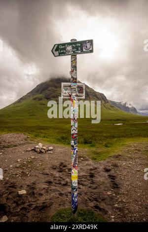 Glencoe, Schottland, Großbritannien. Juli 2024. Auf dem Wanderschild steht Glen Etive am Lairig Gartain 5 Meilen' mit dem Buachaille Etive Beac Berg dahinter. Glencoe in den westlichen schottischen Highlands. Die Gegend ist bekannt für Wasserfälle und Wanderwege, die Gipfel wie Buachaille Etive Mor und Bidean nam Bian erklimmen. Glencoe, ein ausgewiesenes National Scenic Area, das manchmal auch als „Glen of Weeping“ bezeichnet wird, war Schauplatz des berüchtigten „Massakers von Glencoe“ im Jahr 1692. (Kreditbild: © Ruaridh Stewart/ZUMA Press Press Wire) NUR REDAKTIONELLE VERWENDUNG! Nicht für kommerzielle ZWECKE! Stockfoto