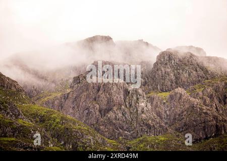 Glencoe, Schottland, Großbritannien. Juli 2024. Blick in Nebel in Richtung Aonach Eagach Ridge wurde als der beste Bergkamm in Großbritannien eingestuft. Glencoe ist ein Dorf im Westen Schottlands. Er liegt im steilen Glencoe Valley in den schottischen Highlands. Die Gegend ist bekannt für Wasserfälle und Wanderwege, die Gipfel wie Buachaille Etive Mor und Bidean nam Bian erklimmen. Glencoe, ein ausgewiesenes National Scenic Area, das manchmal auch als „Glen of Weeping“ bezeichnet wird, war Schauplatz des berüchtigten „Massakers von Glencoe“ im Jahr 1692. (Kreditbild: © Ruaridh Stewart/ZUMA Press Press Wire) NUR REDAKTIONELLE VERWENDUNG! Nicht Stockfoto