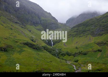 Glencoe, Schottland, Großbritannien. Juli 2024. Glencoe ist ein Dorf im Westen Schottlands. Er liegt im steilen Glencoe Valley in den schottischen Highlands. Die Gegend ist bekannt für Wasserfälle und Wanderwege, die Gipfel wie Buachaille Etive Mor und Bidean nam Bian erklimmen. Glencoe, ein ausgewiesenes National Scenic Area, das manchmal auch als „Glen of Weeping“ bezeichnet wird, war Schauplatz des berüchtigten „Massakers von Glencoe“ im Jahr 1692. (Kreditbild: © Ruaridh Stewart/ZUMA Press Press Wire) NUR REDAKTIONELLE VERWENDUNG! Nicht für kommerzielle ZWECKE! Stockfoto