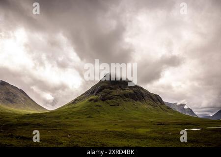 Glencoe, Schottland, Großbritannien. Juli 2024. Der Buachaille Etive Beac Berg und die Sturmwolken. Glencoe in den westlichen schottischen Highlands. Die Gegend ist bekannt für Wasserfälle und Wanderwege, die Gipfel wie Buachaille Etive Mor und Bidean nam Bian erklimmen. Glencoe, ein ausgewiesenes National Scenic Area, das manchmal auch als „Glen of Weeping“ bezeichnet wird, war Schauplatz des berüchtigten „Massakers von Glencoe“ im Jahr 1692. (Kreditbild: © Ruaridh Stewart/ZUMA Press Press Wire) NUR REDAKTIONELLE VERWENDUNG! Nicht für kommerzielle ZWECKE! Stockfoto