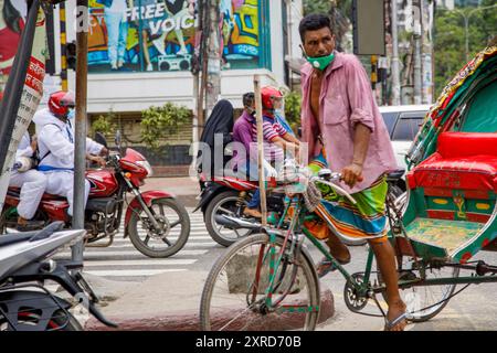 Ein Rikscha-wala oder ein Rikscha-Fahrer, der auf den Straßen von Dhaka nach Passagieren sucht. Die Bewohner der Hauptstadt Dhaka in Bangladesch stellen sich der Bedrohung durch den Corona-Virus COVID 19. Stockfoto