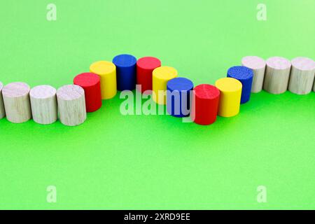 Reihe von Holzzylindern mit mehreren in unterschiedlicher Farbe, die zwei Kurven bilden Stockfoto
