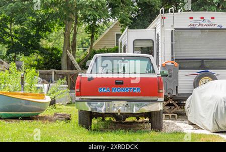 Ein alter Pickup-Truck und andere Fahrzeuge in einem Hinterhof Stockfoto