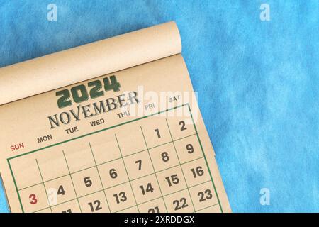 November 2024 Kalender flach gelegt in blauem Hintergrund mit Kopierraum. Stockfoto