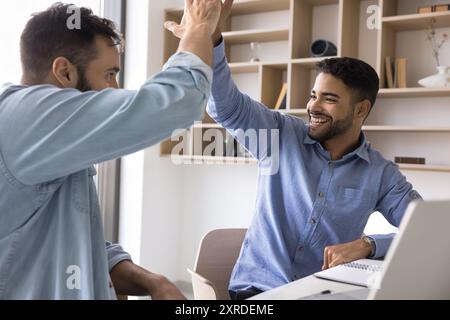 Zwei verschiedene Geschäftsleute geben hohe fünf, klatschen die Hände Stockfoto