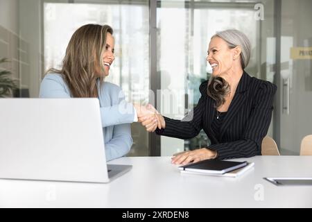 Zufriedener Kunde und positiver Berater geben Handschlag Stockfoto