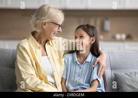 Glückliche, liebevolle Großmutter umarmt glückliche, schöne Enkelin Stockfoto