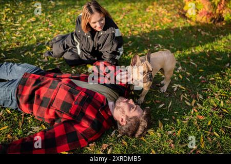 Paare und ihr Hund haben eine tolle Zeit im Park während der farbenfrohen Herbstsaison Stockfoto
