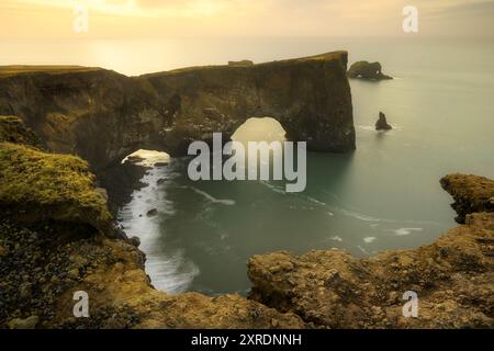 Dyrholaey Bogengestein in Island, in der Nähe von Vik, neben schwarzem Sandstrand, bei Sonnenaufgang Stockfoto