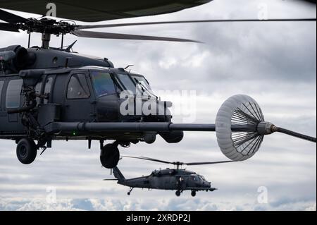 Ein HH-60G Pave Hawk Helikopter erhält Kraftstoff von einem HC-130J Combat King II Schlauch- und Drogue-System während eines Hubschrauber-Luft-Betankungstrainings e Stockfoto