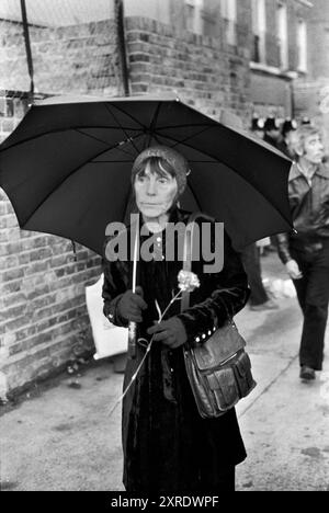 Ein Trauer trägt eine rote Nelke, die auf das Grab von Blair Peach geworfen wird. Tausende nahmen an der Beerdigung Teil. Southall, London, England 13. Juni 1979 1970, UK HOMER SYKES Stockfoto