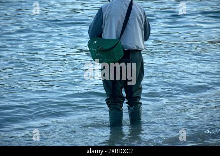 Die traditionelle Kleidung eines Fischers, der im Wasser watet, ausgestattet mit robusten Stiefeln und einem Korb für den Fang. Die Stiefel sind so konzipiert, dass sie Stockfoto